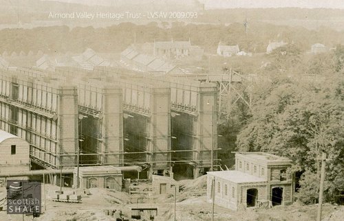 Close up view of Niddry Castle oil works from the bing, showing high level trestle through the trees on the right, transporting shale to the top of the retorts. The brick building on the right is the electric railway loco shed.